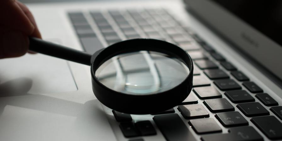 A magnifying glass and a laptop keyboard