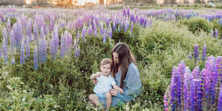 A woman holding a young children in a field of flowers