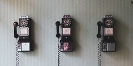 Three old-fashioned phones on a wall 