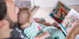 An adult reading to an infant