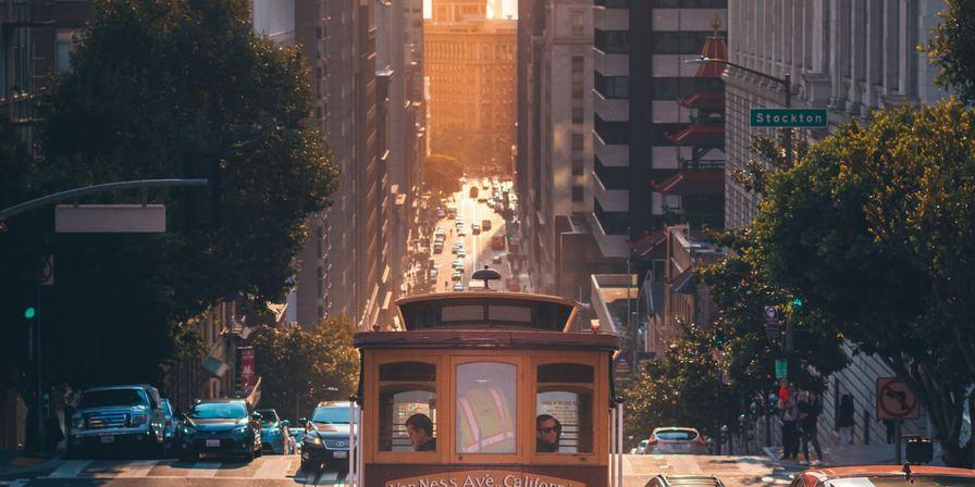San Francisco trolly coming up a hill at sunset