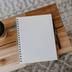 Wooden table with coffee cup and notepad