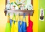 Coat hanger shelf, holding multiple green, blue, yellow, and red child aprons