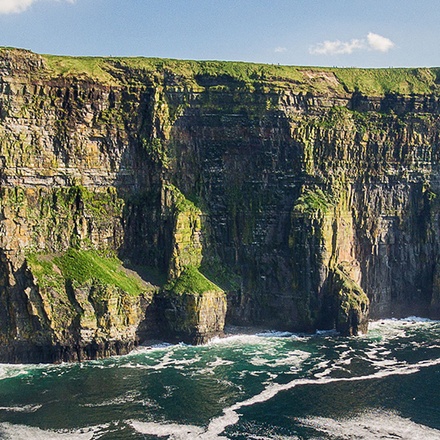A view of the Cliffs of Moher in Wales on a sunny day.