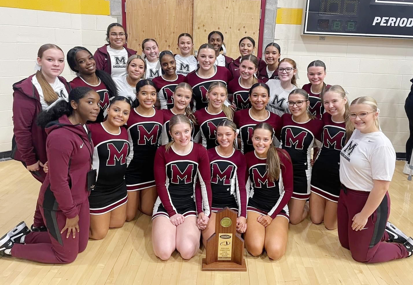 Cheer team in maroon and black uniforms with "M" on the front.