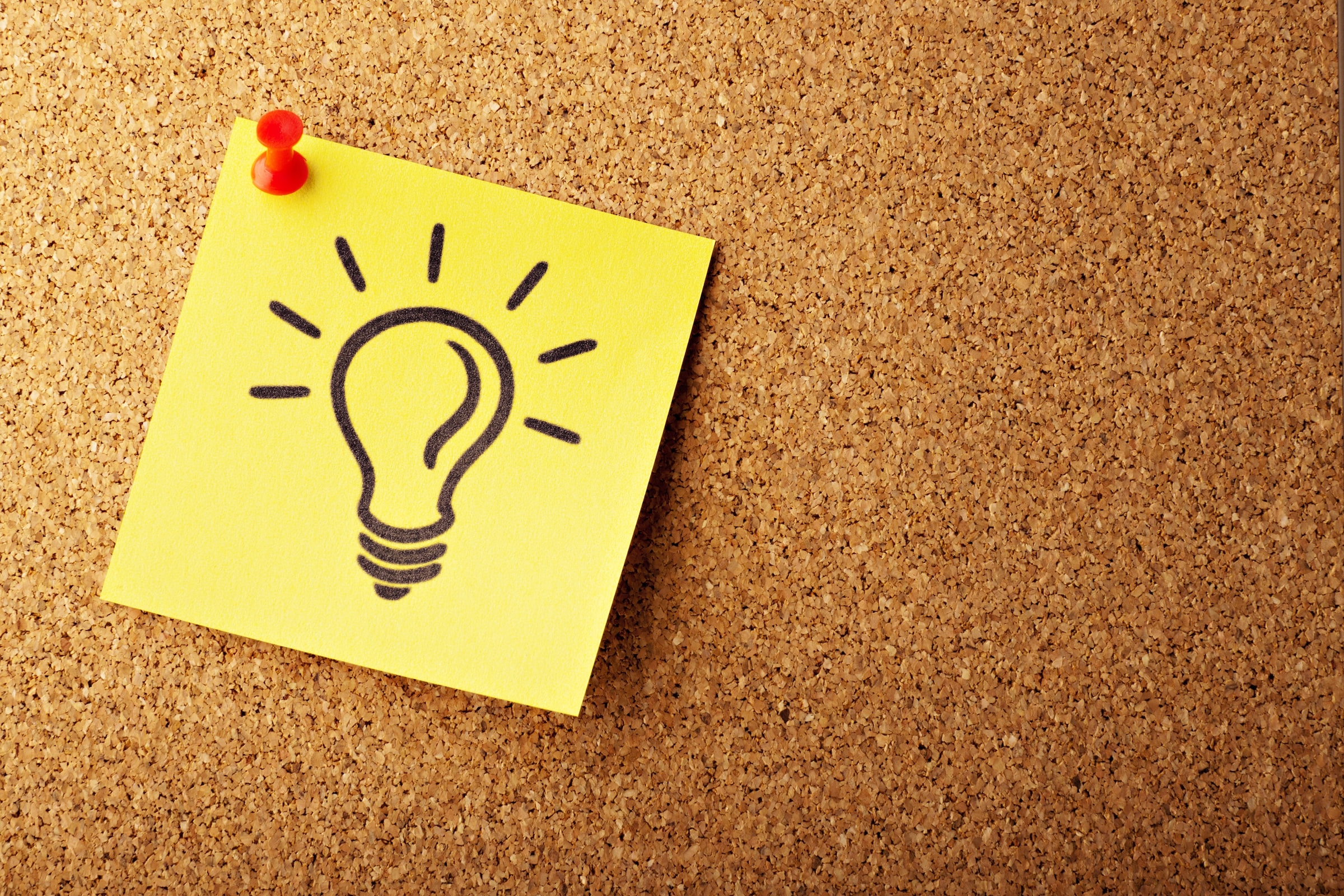 a bulb image on a yellow post-it is pinned on a board stock image