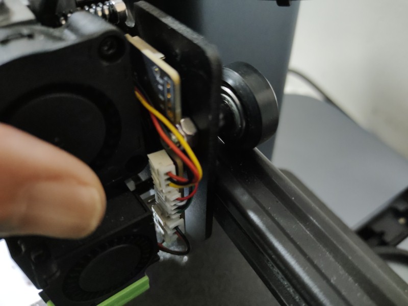 Image shows the extruder assembly of a 3D printer, highlighting a probable misalignment issue on the X-axis rail causing print failures.