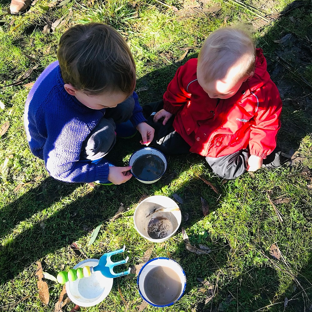 Children playing with cups of mud