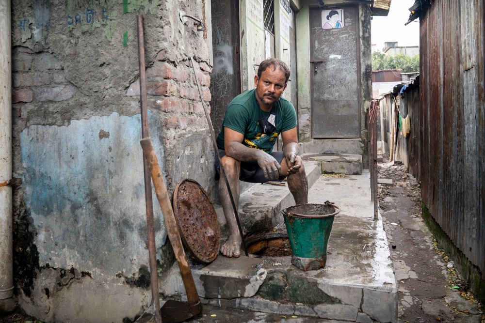 Delowar Hossain tömmer latriner och rensar avlopp i Dhaka, Bangladesh. Ett arbete han utför utan skyddsutrustning som handskar. Foto: WaterAid/DRIK/Habibul Haque 