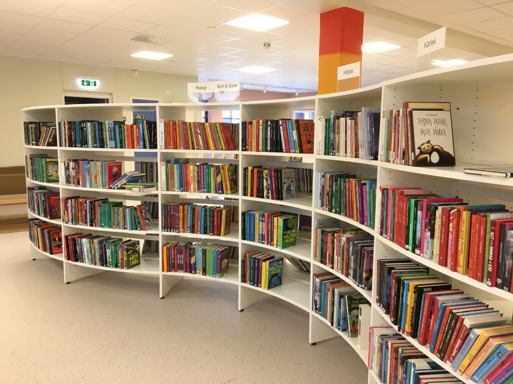 Vågformad bokhylla fylld med böcker på Lindesbergs nyrenoverade bibliotek. 