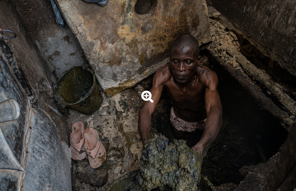 Iliyasu Abbas, sanitetsarbetare i Nigeria, tömmer latriner på avföring med sina bara händer. Foto: WaterAid/Nelson Owoichi
