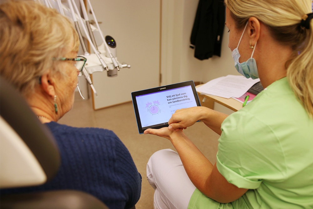 Isabella Karlsson, tandhygienist vid Hälsan Folktandvård Jönköping, visar en av de första patienterna som ska testa den nya appen hur den fungerar.