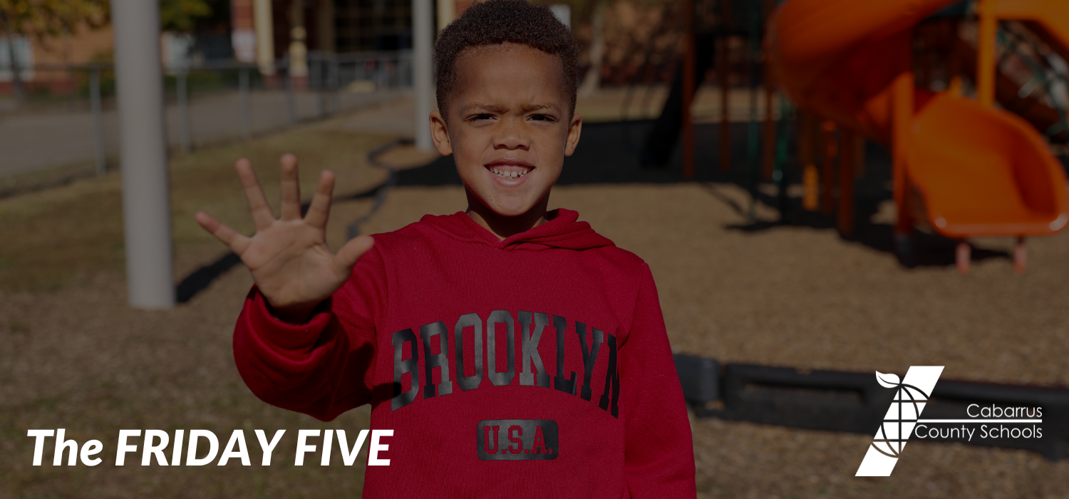 A student holding up five fingers.