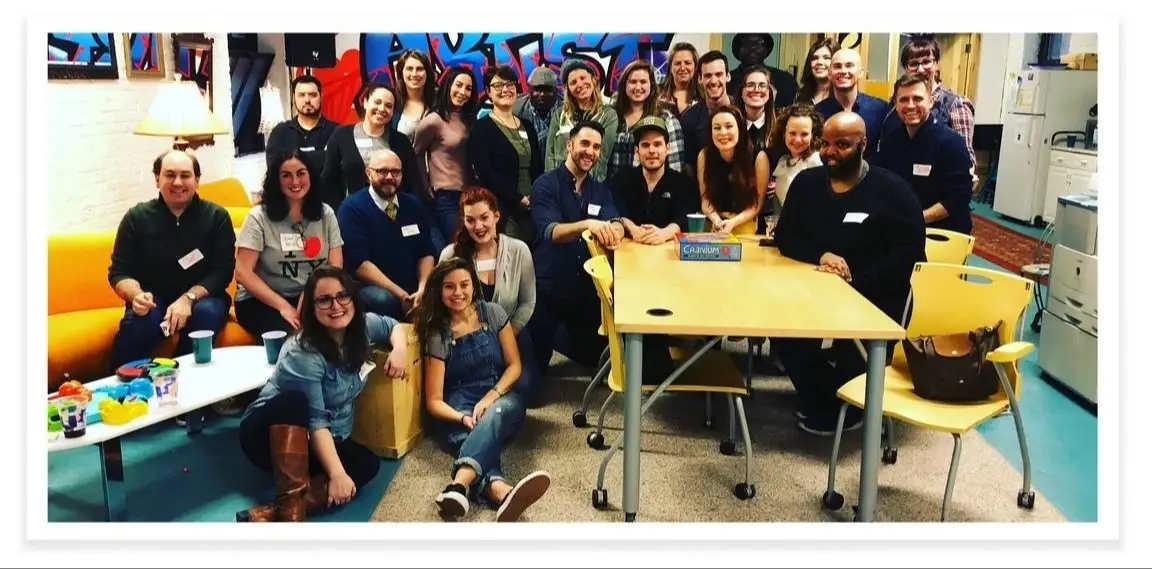 A group of people in an office posing and smiling.