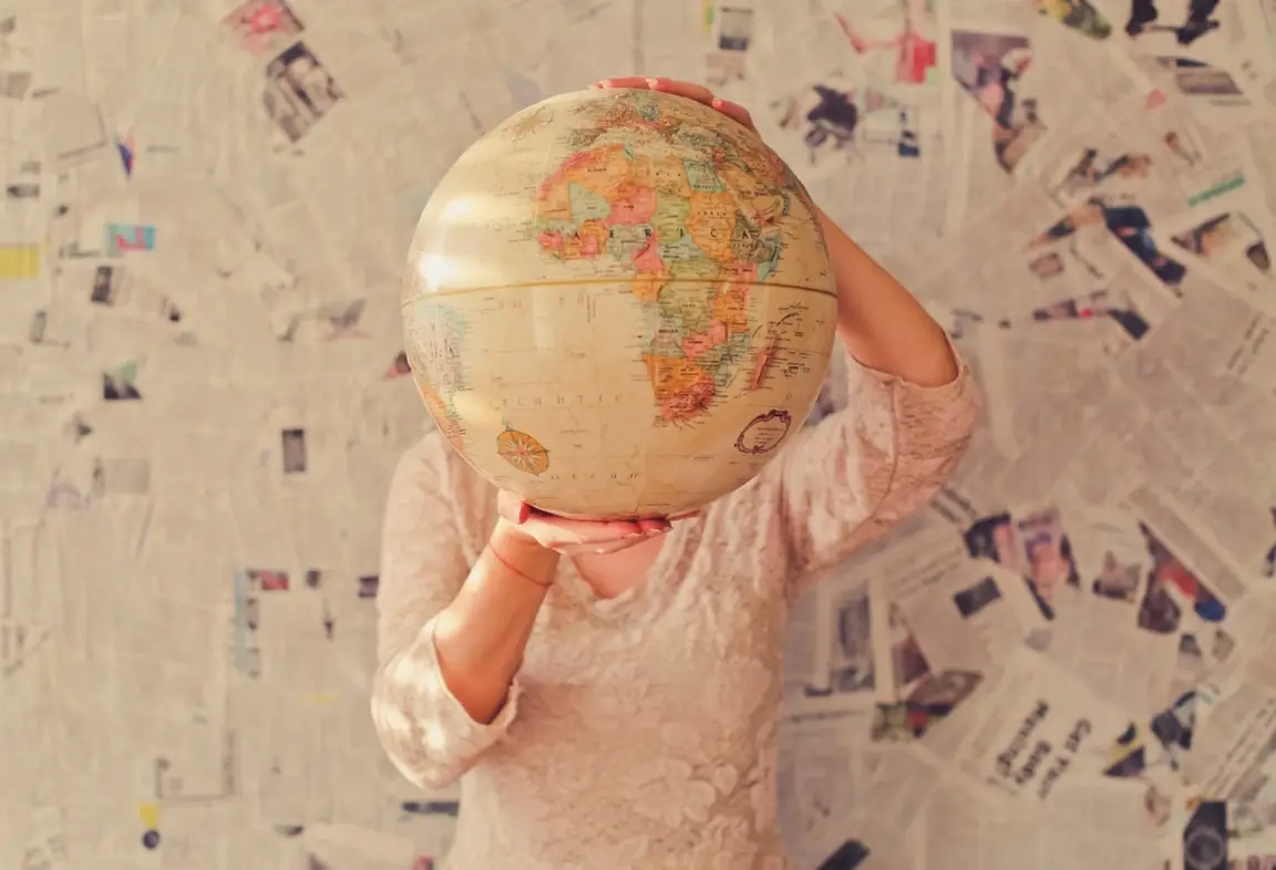 A person holding globe.