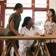 mulheres reunindo e conversando em mesa de trabalho