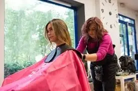Woman getting ready to cut another woman's hair.