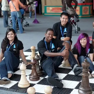 Discovery Corps Members sitting on an interactive chess game board