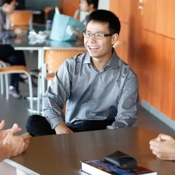 Students having a conversation while sitting around a table