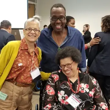 Two Black women and a Black male at a meeting