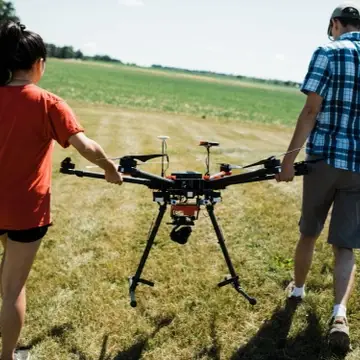 Two students walking with drone