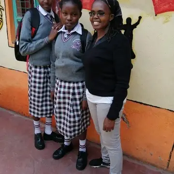 Our founder Margret Standing with two school girls