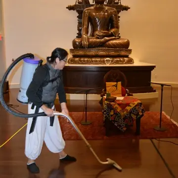 Volunteer vacuuming Milarepa Hall