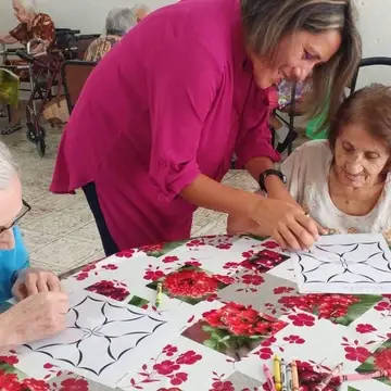 a woman makes art with an elderly woman