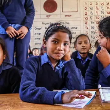 Nepali girls in a classroom looking at the camera
