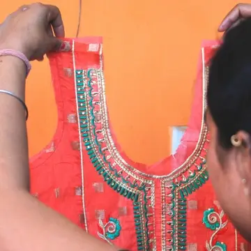 woman holding ready made kurti at Sewing New Futures Shakti Boutique