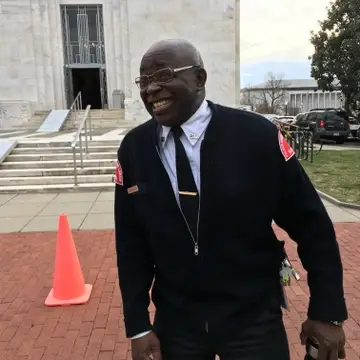 security officer smiling on the job in front of the Folger Shakespeare Library stairs