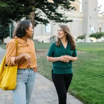 Dr. Vicki Johnson, Founder and Director of ProFellow speaking with a female  graduate school student on the campus of the University of San Francisco in San Francisco, California, USA.