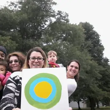 Group outside holding the Idealist logo