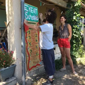 Man painting a board while woman looks on.