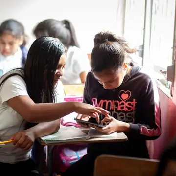2 students in Honduras using a tablet