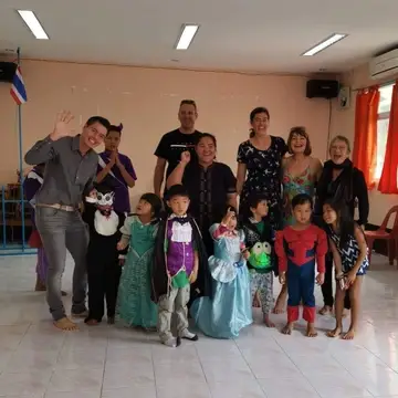 Group of people smile for a photo, children wearing costumes