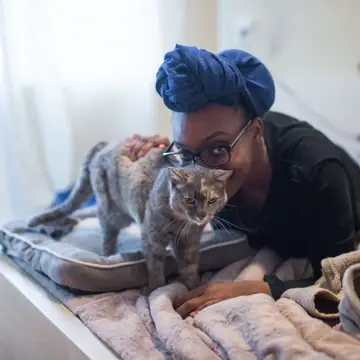 A foster pets her foster cat.