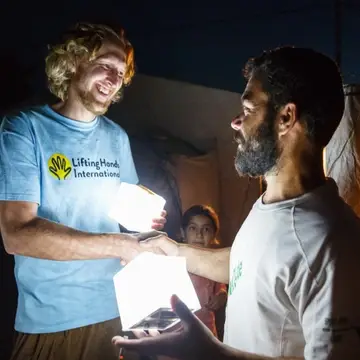 Yazidi refugee receiving solar light