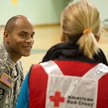 A Red Cross Volunteer works with a US service member in a shelter
