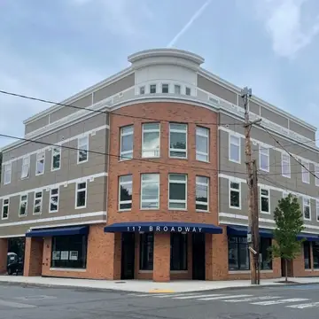 three story multi-family building with commercial space on ground floor