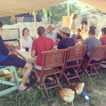 A group of volunteers eating dinner outdoors.