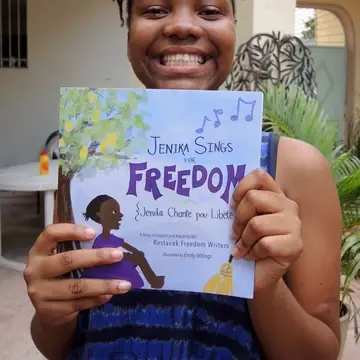 a young author poses with her book