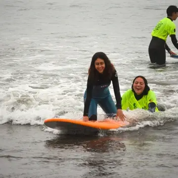 Girl smiling as she surfs first wave