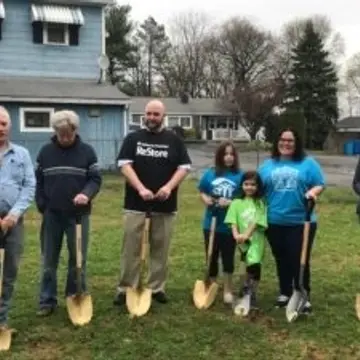 The sun was bright on April 13th, a Saturday morning, as we kicked off the seventeenth Warren County Habitat for Humanity home construction project for our newest partner family, Robin and Joshua Maguire.  The family of four was joined by family, friends, volunteers, supporters and other well-wishers at the future construction site, 515 Dana St., Lopatcong Township. Board President John Rolak welcomed the crowd and explained how the family selection process works. “There is a misconception that Habitat for Humanity gives homes to people. That isn’t so,” he explained. “Families are required to make a down payment, hold a mortgage, and perform two hundred and fifty hours of sweat equity per adult.”