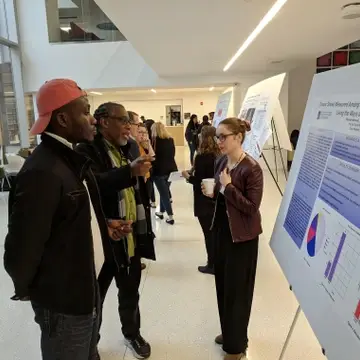 Student and Faculty presenting a research poster