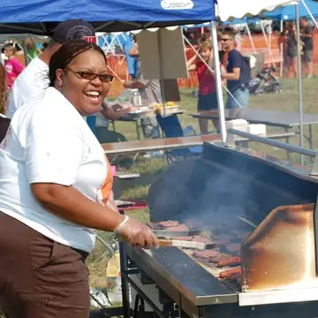 Volunteer grilling food during our Mud Volleyball event