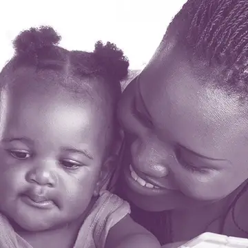 A mother and daughter read a book.