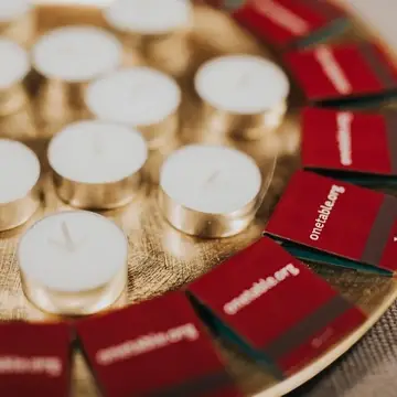 tea lights and onetable branded matches on a gold tray