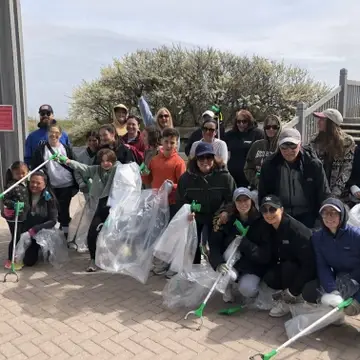 group of people pose at a beach cleanup