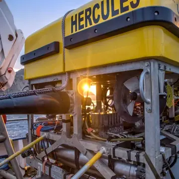 Sun shining through the frame of Remotely Operated Vehicle Hercules which has a yellow foam cap and metal frame.